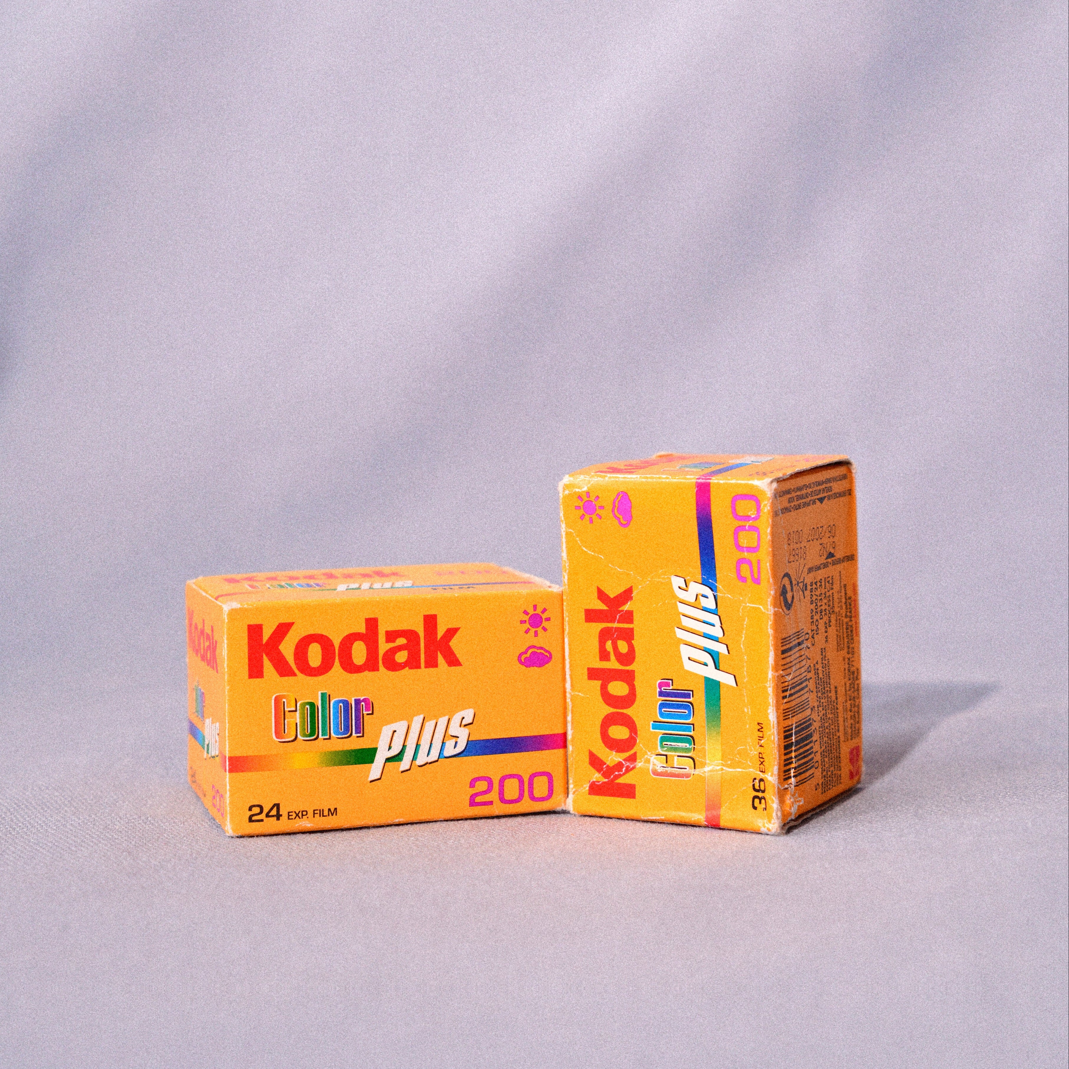 Two boxes of Kodak Color Plus 200 film on a gray background
