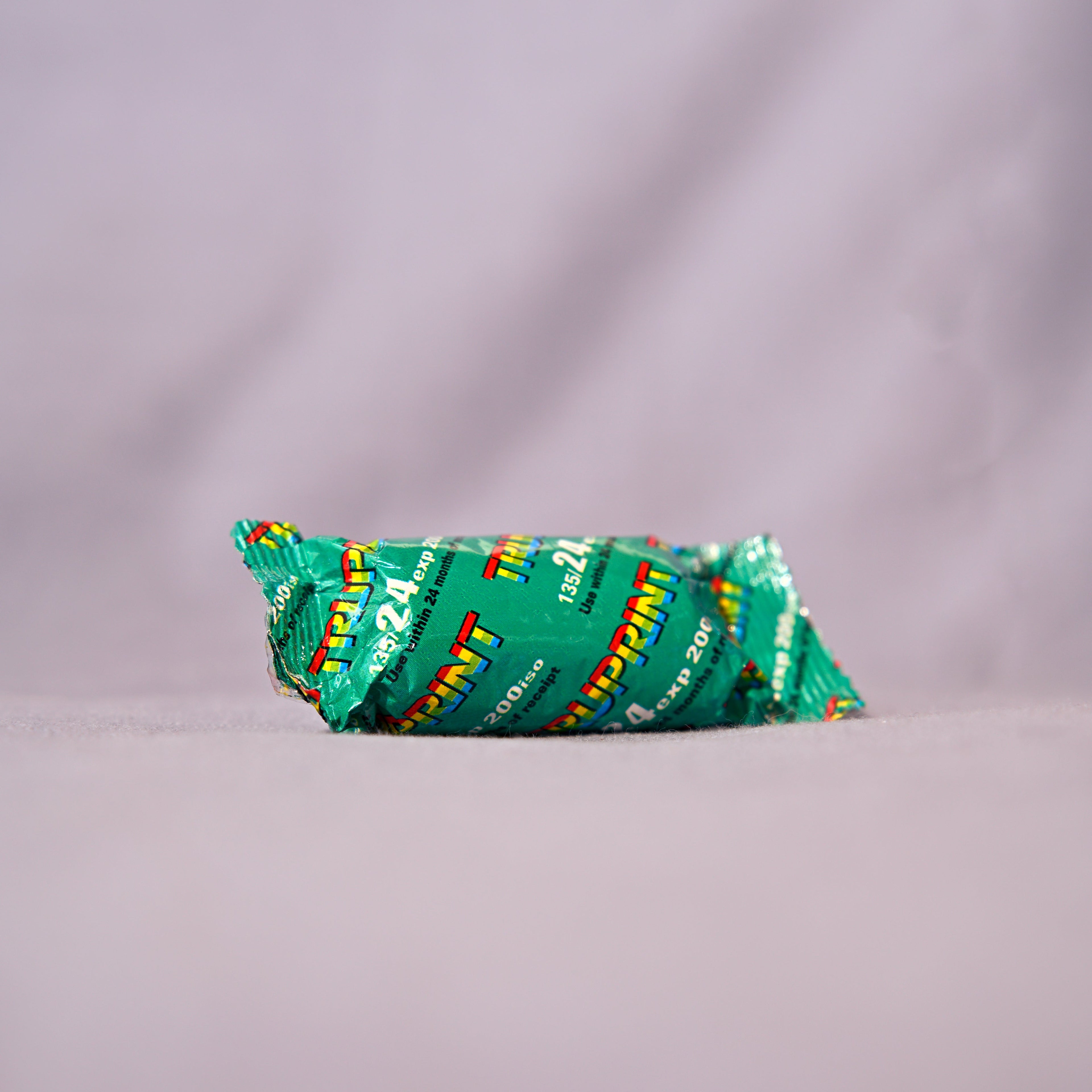 Green candy bar with colorful wrapper on a gray background