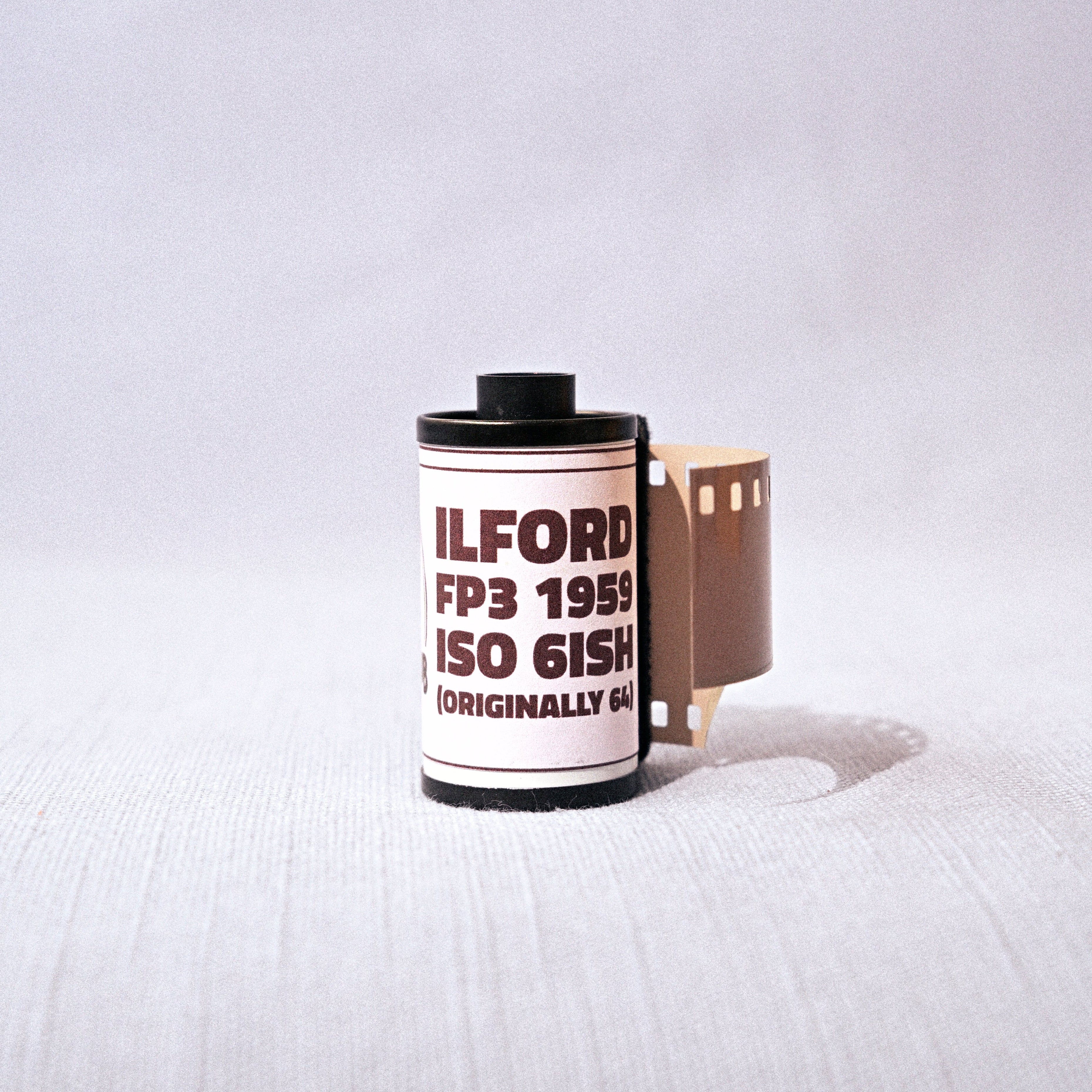 Film canister shaped like a camera on a white background