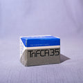A vintage box of Tri-Fast 35 film, manufactured by Film Corporation of America, shown on a light gray fabric background.