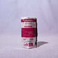 A roll of Fujifilm Color Neg 120 film, wrapped in its original paper packaging with a prominent magenta and white label, standing upright on a light gray textured surface against a matching light gray backdrop.