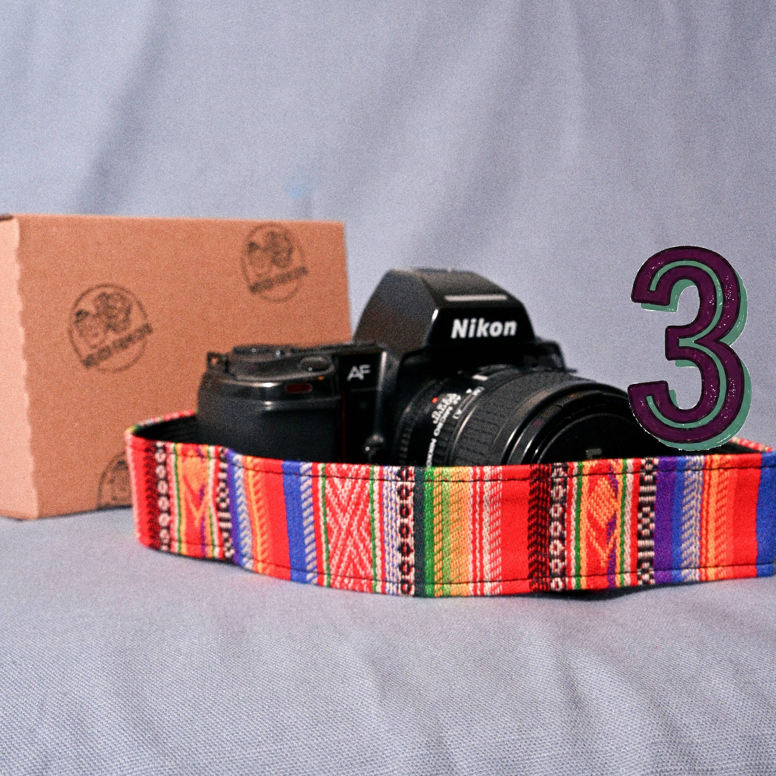 Nikon camera on a colorful strap with a cardboard box in the background